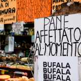 ...dove diversi cartelli colorati recitano �pane affettato al momento� o �bufala e mozzarella a chilometro zero�
